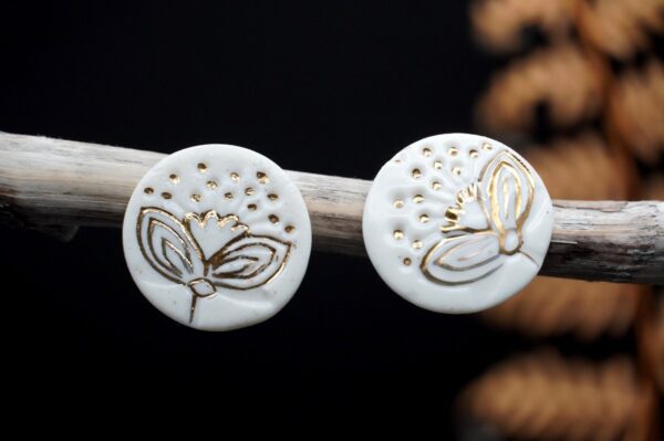 Each piece is handmade from porcelain clay and fired twice or three times in the kiln around 1200 degrees. Pottery is my passion and I love to discover new techniques, glazes, oxides or materials to play with and make extraordinary high quality jewellery. I also use hypoallergenic stainless steel and silver studs/hooks. White porcelain earrings with gold luster Pohutukawa flowers Christmas edition.