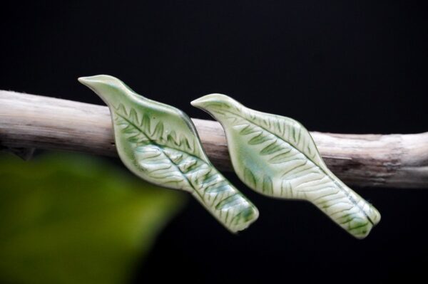 Each piece is handmade from porcelain clay and fired twice or three times in the kiln around 1200 degrees. Pottery is my passion and I love to discover new techniques, glazes, oxides or materials to play with and make extraordinary high quality jewellery. I also use hypoallergenic stainless steel and silver studs/hooks. Porcelain Tui bird earrings.